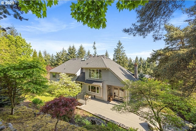 rear view of house with french doors and a wooden deck