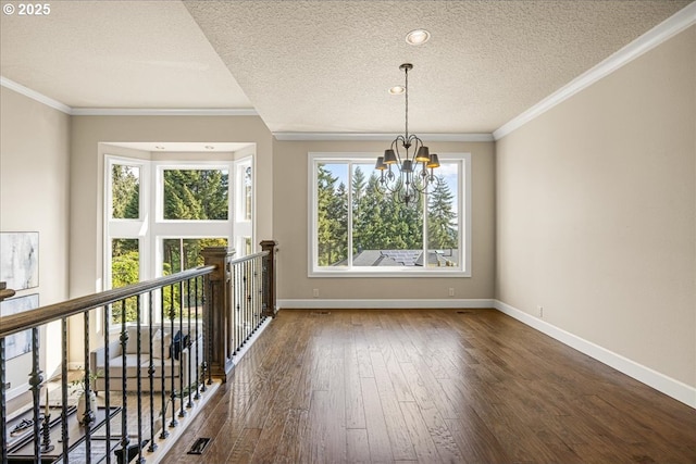 unfurnished dining area with dark wood-type flooring, a textured ceiling, baseboards, and a notable chandelier