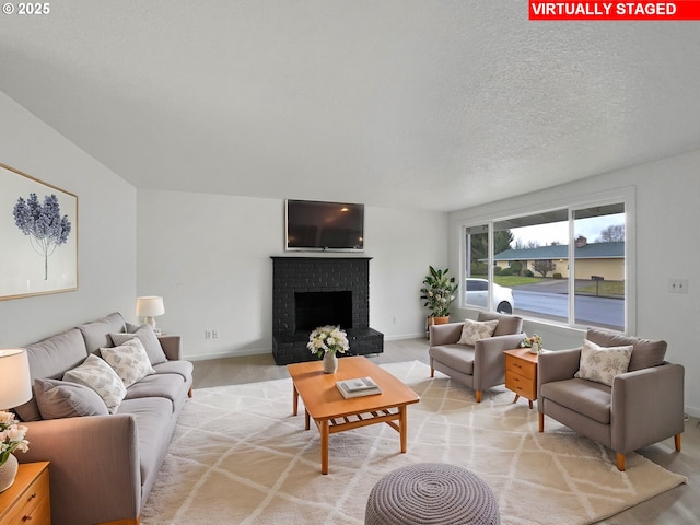 living room with light carpet, a fireplace, and a textured ceiling