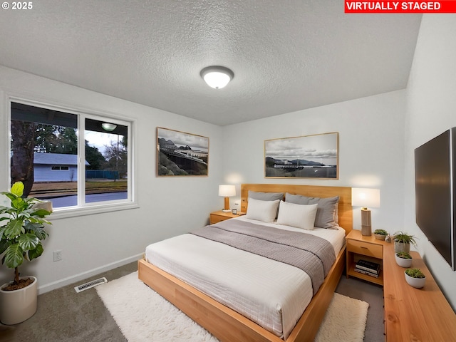 bedroom featuring carpet flooring and a textured ceiling