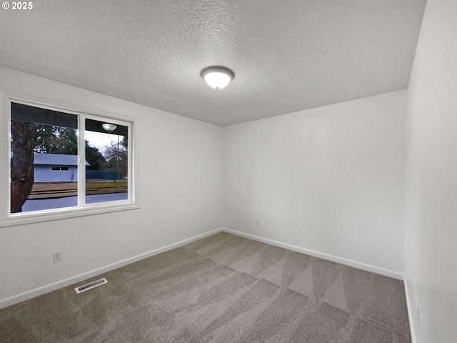 carpeted spare room featuring a textured ceiling