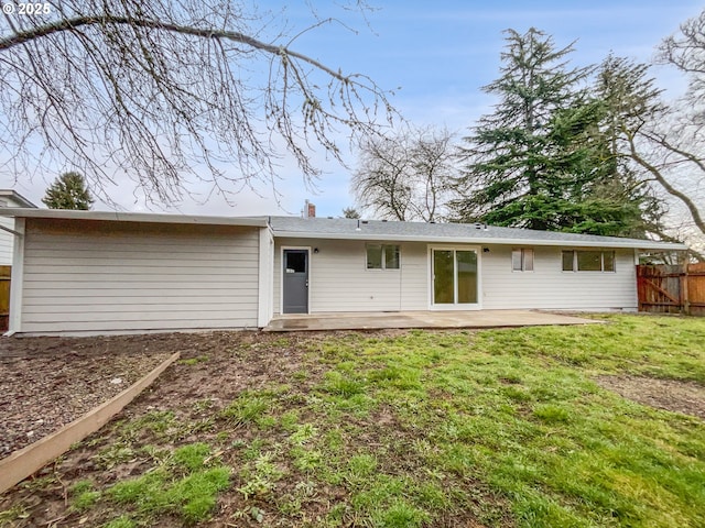 back of property featuring a patio area and a lawn