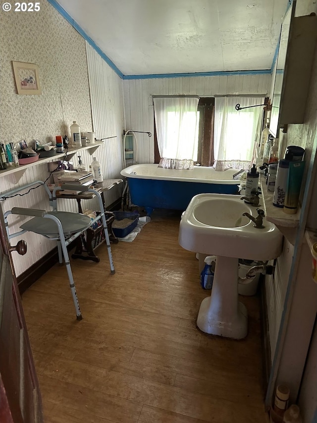 bathroom with ornamental molding, hardwood / wood-style floors, and a bathtub