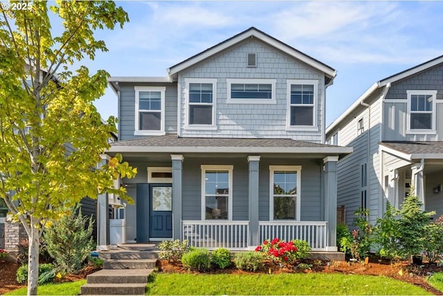 traditional home with a porch and roof with shingles
