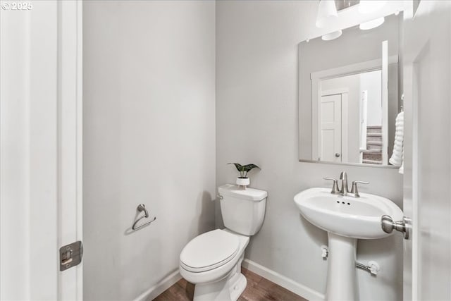 bathroom featuring baseboards, toilet, and wood finished floors