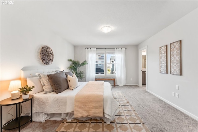 bedroom featuring connected bathroom, baseboards, and light carpet