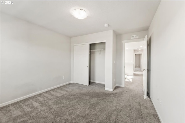 unfurnished bedroom with carpet floors, baseboards, a closet, and visible vents