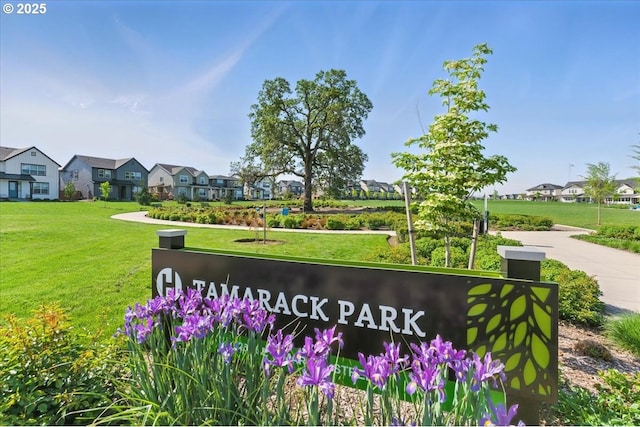 community sign with a lawn and a residential view