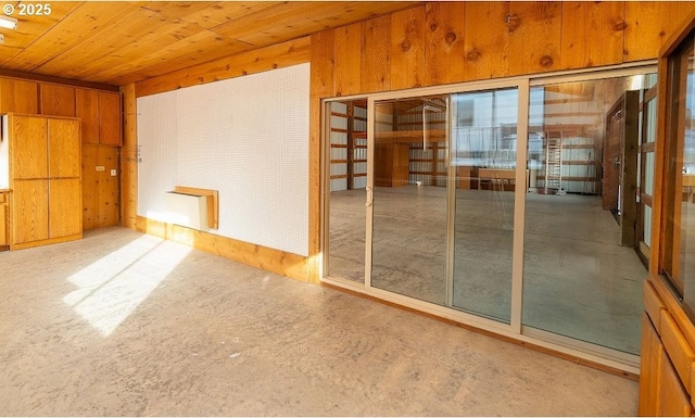 unfurnished room featuring wood ceiling and wood walls