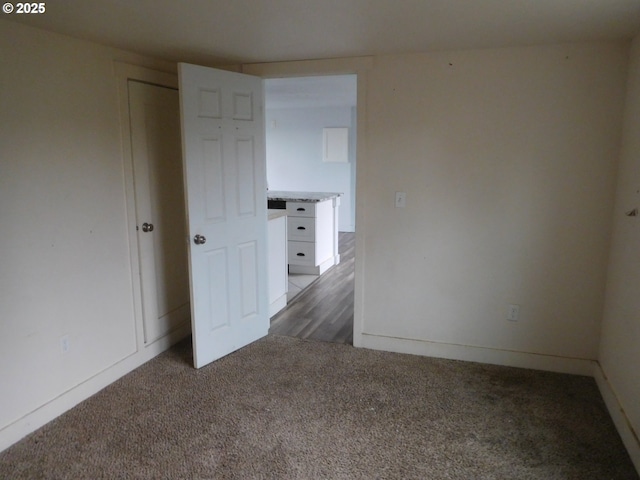 unfurnished room with dark colored carpet