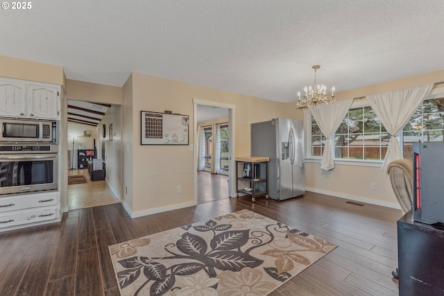 dining area with hardwood / wood-style flooring, a textured ceiling, and a chandelier