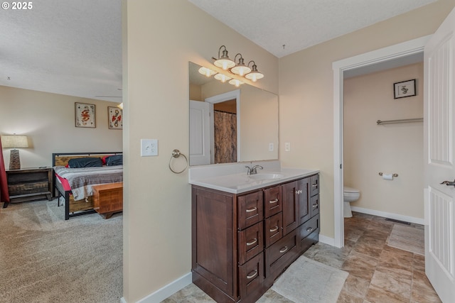 bathroom featuring vanity, a textured ceiling, and toilet