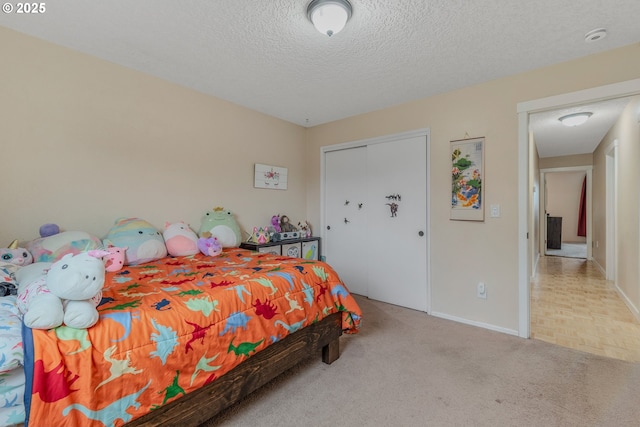 bedroom with light colored carpet, a closet, and a textured ceiling