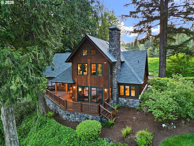 44050 Mckenzie Hwy, Leaburg, OR 97489 - rear view of property featuring a shingled roof, a chimney, covered porch, and stone siding