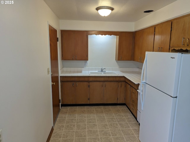 923 S Fir St, Salem, OR 97302 - kitchen with freestanding refrigerator, a sink, brown cabinets, and tile counters