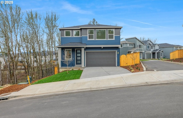 view of front of house featuring fence, a garage, and driveway