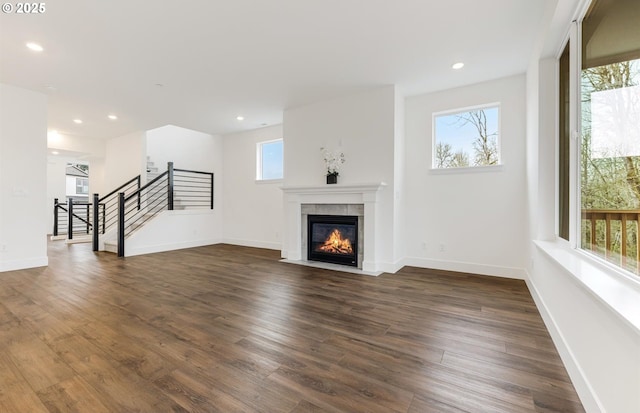 unfurnished living room with recessed lighting, a tile fireplace, and dark wood-style flooring