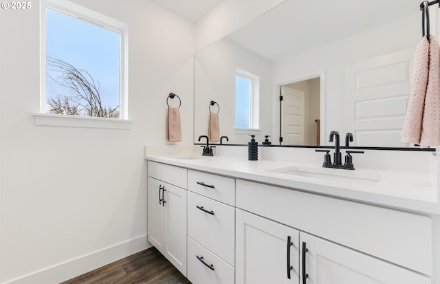 bathroom with a sink, baseboards, and a wealth of natural light