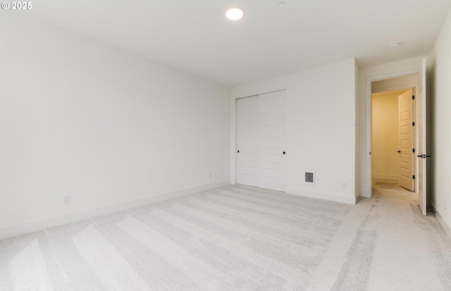 unfurnished bedroom featuring visible vents, baseboards, light carpet, recessed lighting, and a closet