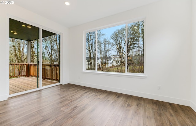 unfurnished room featuring recessed lighting, baseboards, and wood finished floors