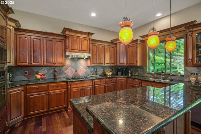 6147 Quail Hollow St, Salem, OR 97306 - kitchen with under cabinet range hood, dark wood finished floors, decorative light fixtures, recessed lighting, and backsplash