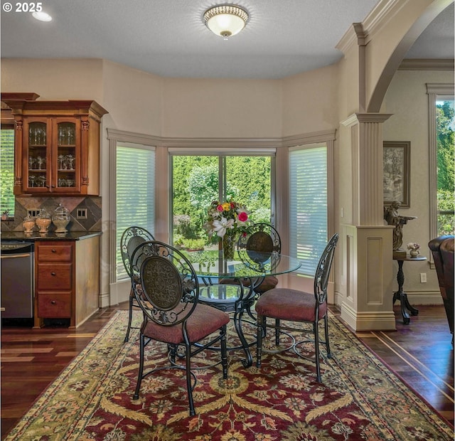 6147 Quail Hollow St, Salem, OR 97306 - dining space featuring dark wood-type flooring, arched walkways, ornate columns, and ornamental molding