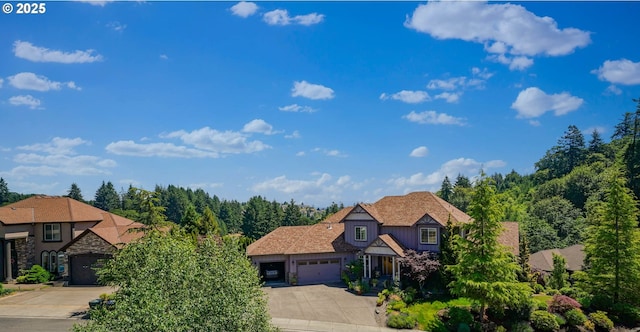 6147 Quail Hollow St, Salem, OR 97306 - view of front of house featuring concrete driveway, a garage, stone siding, and board and batten siding