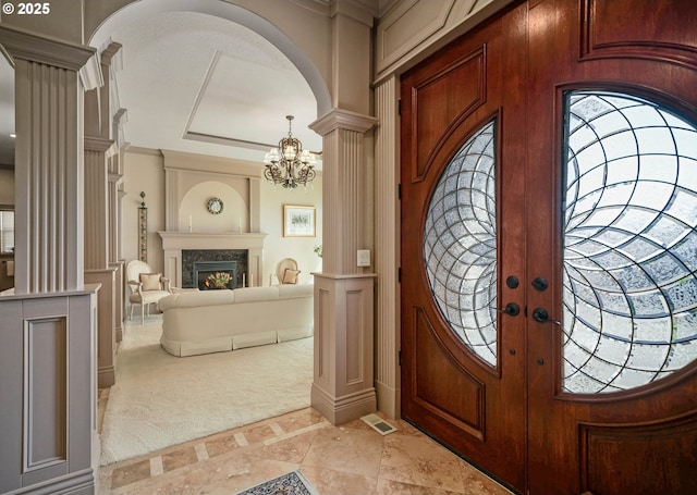 6147 Quail Hollow St, Salem, OR 97306 - entrance foyer with decorative columns, arched walkways, inlaid floor details, a high end fireplace, and a chandelier