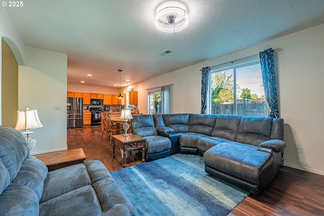 1131 Veronica Ln, Eugene, OR 97404 - living area featuring dark wood finished floors, arched walkways, recessed lighting, and a textured ceiling