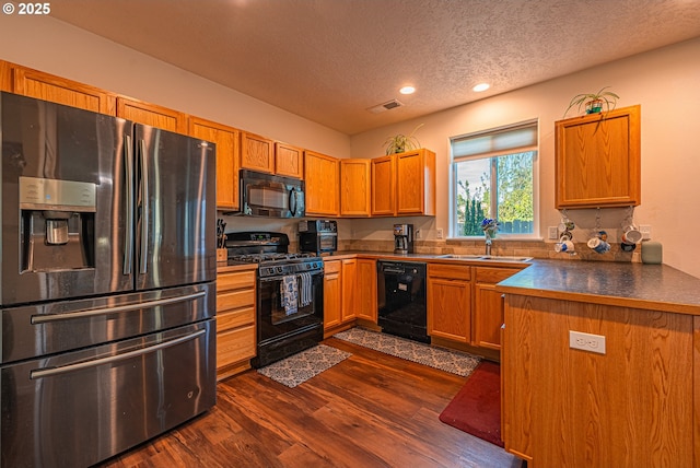 1131 Veronica Ln, Eugene, OR 97404 - kitchen featuring black appliances, a textured ceiling, dark wood-type flooring, recessed lighting, and dark countertops