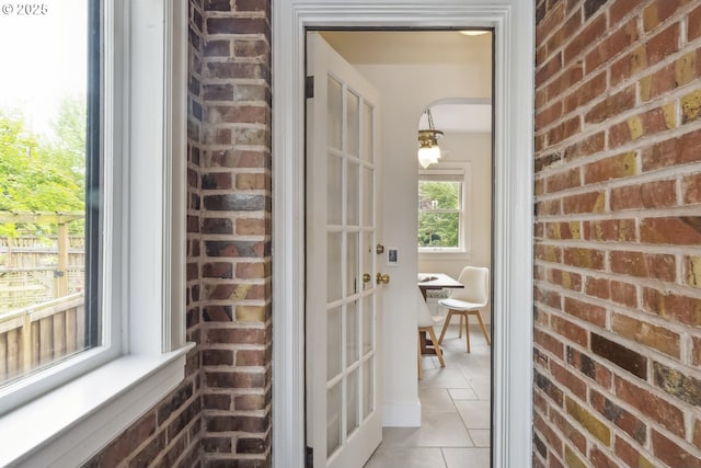3622 NE Hassalo St, Portland, OR 97232 - hallway featuring light tile patterned floors and brick wall