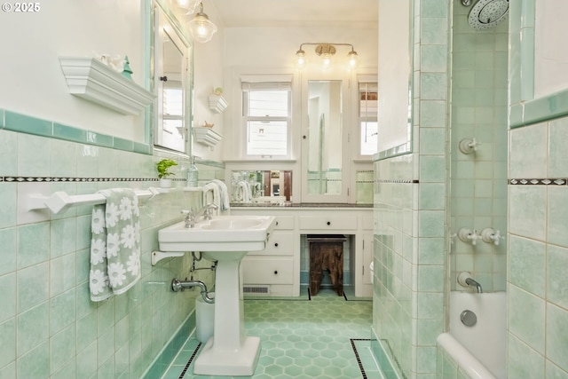 3622 NE Hassalo St, Portland, OR 97232 - bathroom featuring tile walls, tiled shower / bath, wainscoting, and tile patterned floors
