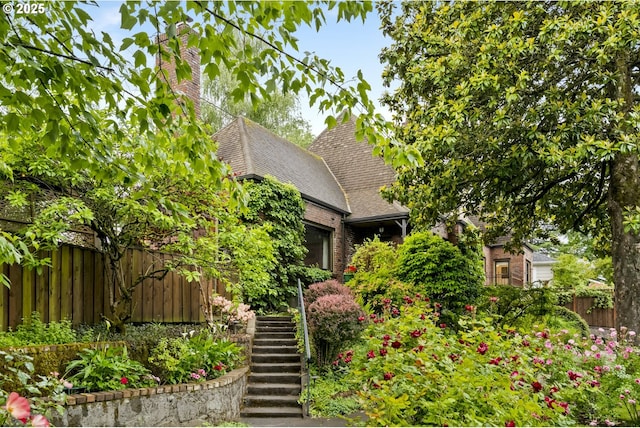 3622 NE Hassalo St, Portland, OR 97232 - obstructed view of property featuring an attached garage, a shingled roof, stairs, and brick siding
