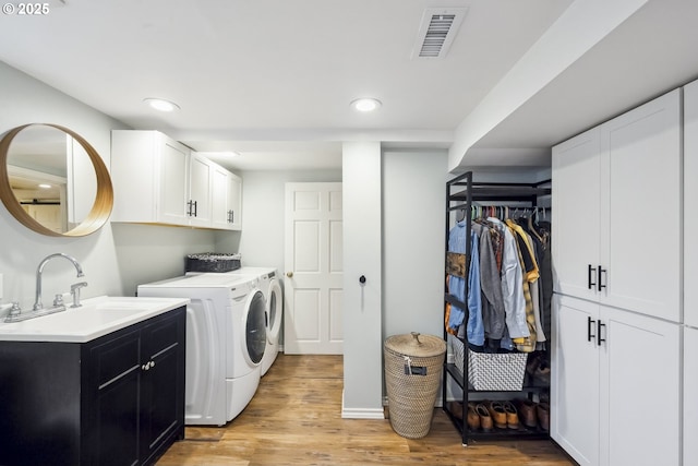 3622 NE Hassalo St, Portland, OR 97232 - laundry area featuring cabinet space, separate washer and dryer, light wood-style floors, and recessed lighting