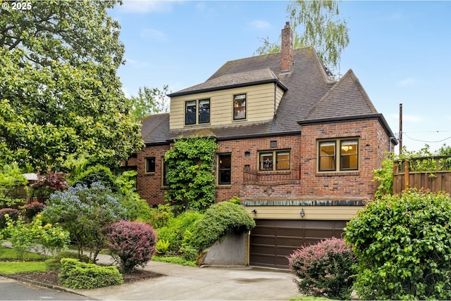 3622 NE Hassalo St, Portland, OR 97232 - view of front of house with brick siding, a garage, concrete driveway, and a chimney