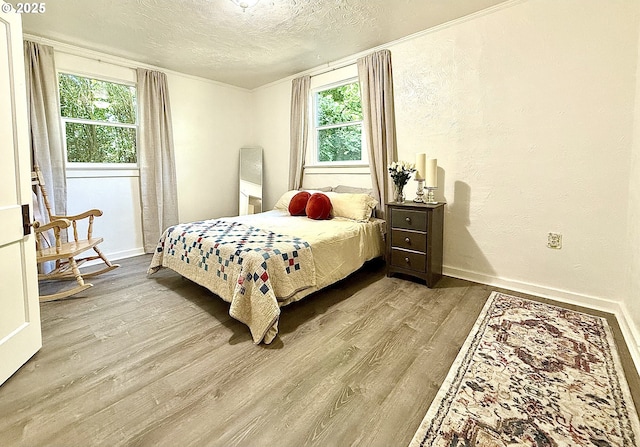 632 SW Utah St, Camas, WA 98607 - bedroom with wood finished floors, a textured ceiling, multiple windows, crown molding, and a textured wall