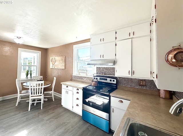 632 SW Utah St, Camas, WA 98607 - kitchen with stainless steel range with electric cooktop, white cabinets, tasteful backsplash, light wood-style flooring, and under cabinet range hood