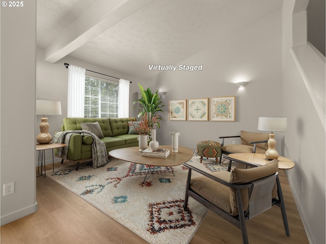living room with wood finished floors, beamed ceiling, and baseboards