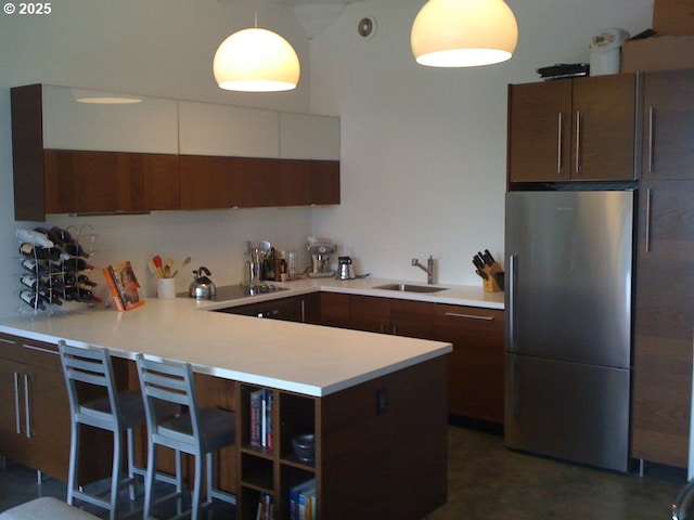 1314 NW Irving St Unit 613, Portland, OR 97209 - kitchen with freestanding refrigerator, a peninsula, light countertops, a sink, and black electric cooktop