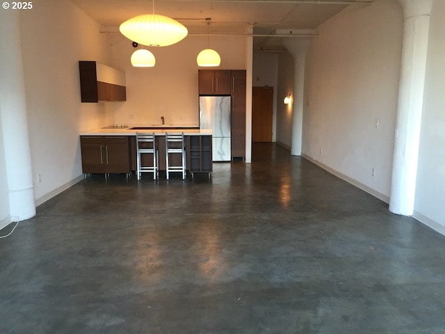 1314 NW Irving St Unit 613, Portland, OR 97209 - kitchen featuring freestanding refrigerator, concrete floors, light countertops, and a breakfast bar area
