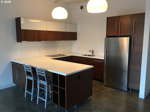 1314 NW Irving St Unit 613, Portland, OR 97209 - kitchen featuring freestanding refrigerator, concrete floors, black electric stovetop, and a peninsula