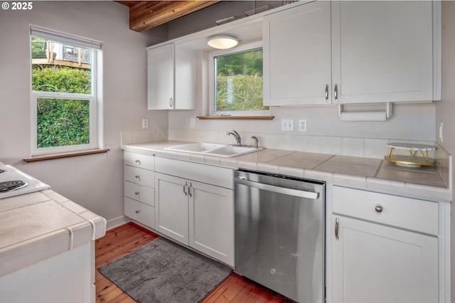 kitchen featuring dishwasher, light wood-style flooring, beamed ceiling, white cabinetry, and a sink