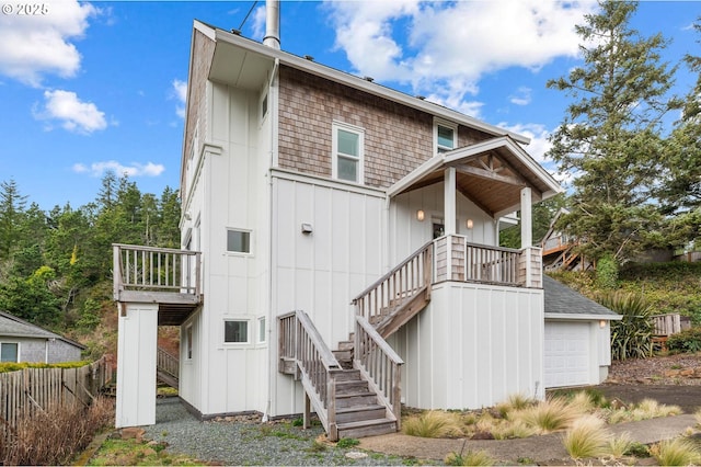 back of property featuring a garage, stairs, and board and batten siding