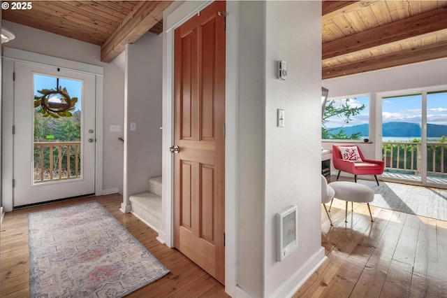 doorway with wooden ceiling, a mountain view, visible vents, hardwood / wood-style floors, and beamed ceiling