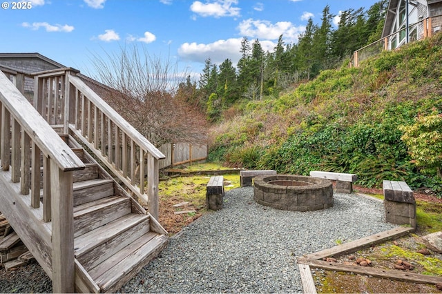 view of yard with stairway, a patio area, fence, and a fire pit