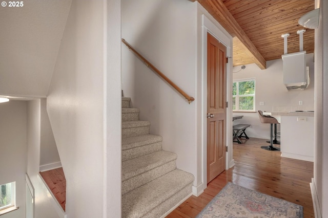 stairs with wood ceiling, baseboards, wood finished floors, and beamed ceiling