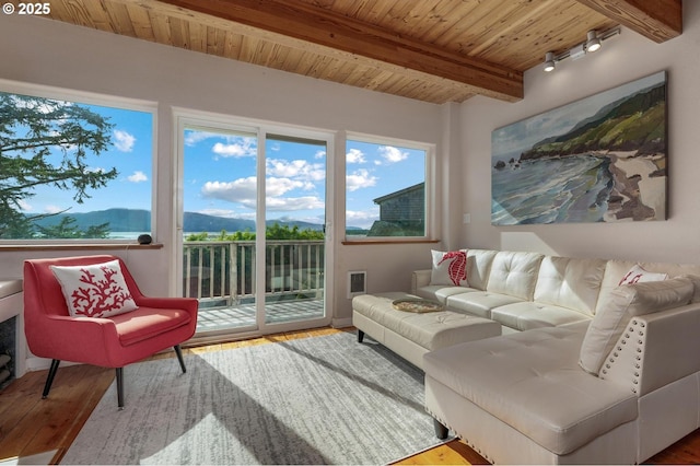 sunroom featuring wood ceiling, beamed ceiling, and a mountain view