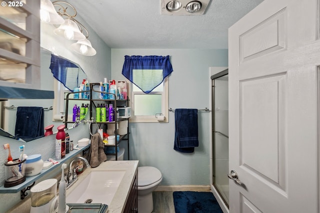 bathroom with hardwood / wood-style floors, an enclosed shower, vanity, a textured ceiling, and toilet