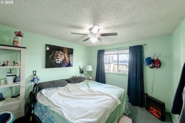 bedroom featuring ceiling fan, carpet floors, and a textured ceiling