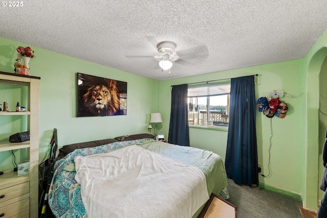 bedroom with ceiling fan, carpet floors, and a textured ceiling